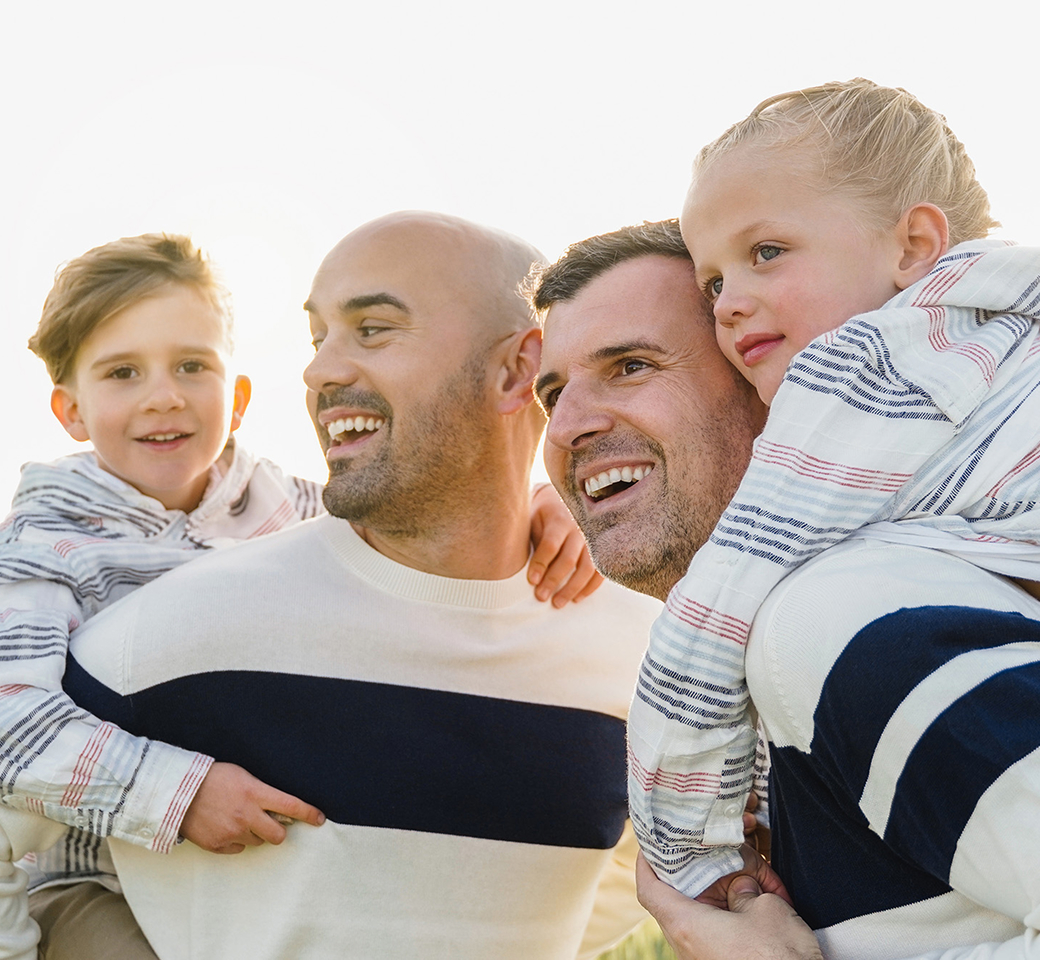 gay dads playing in the field with their kids